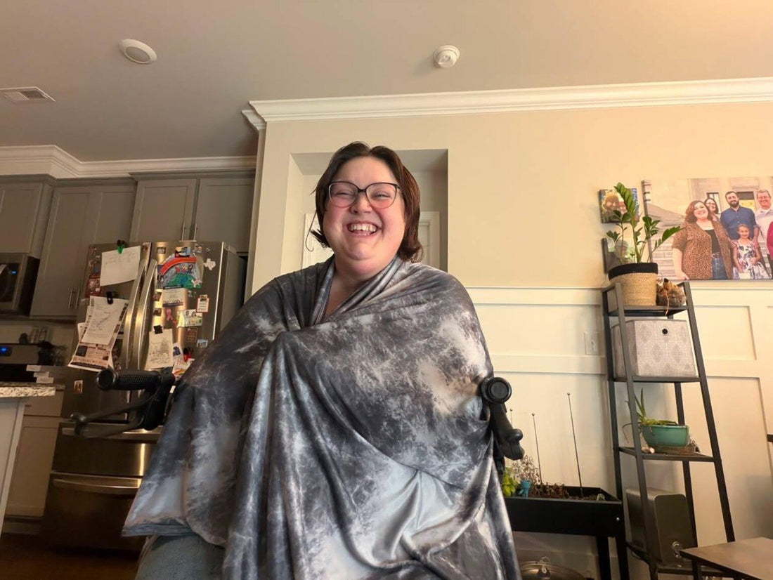 Chelsea smiling while wrapped in a gray IceBlankie CoolSleep Cooling Blanket